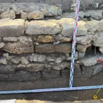 Камяна стіна вежі Хаджибейського замку на археологічних розкопках з мірними рейками